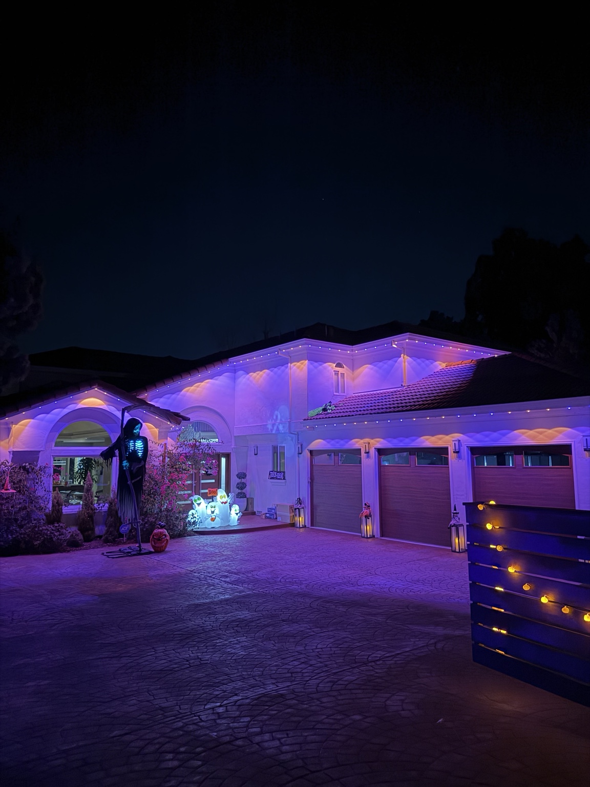 Home lit in orange and purple permanent Halloween lighting at night