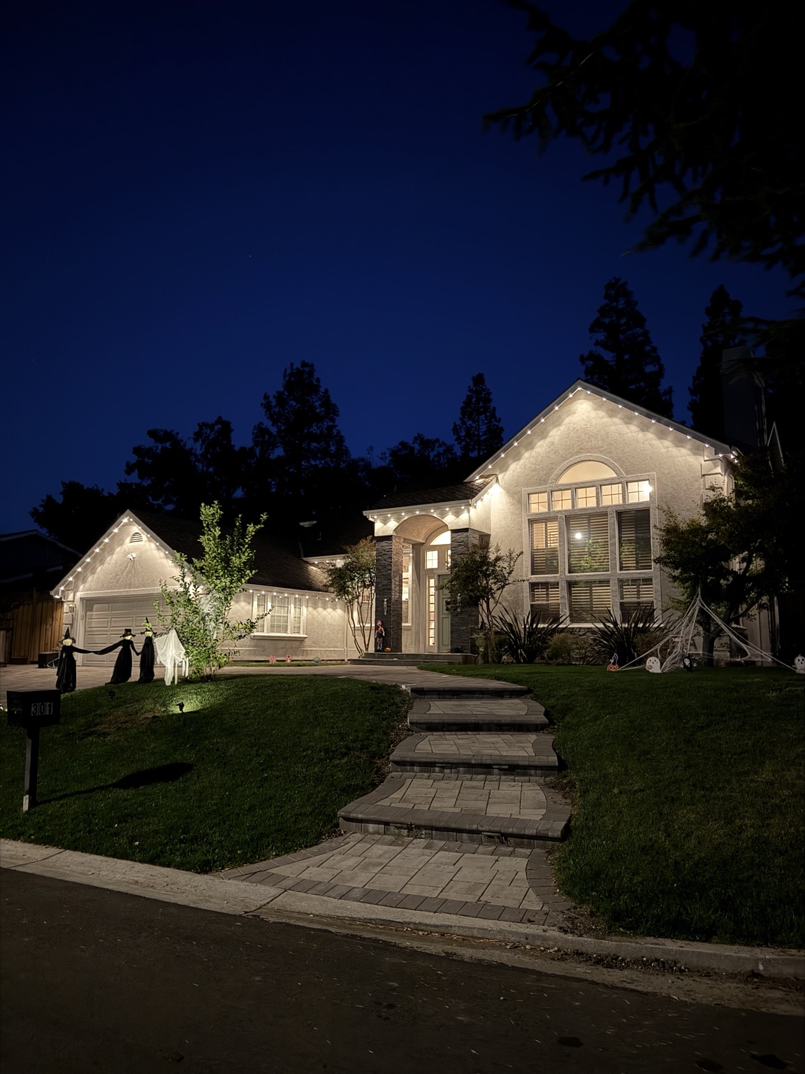 Luxury Bay Area two-story home at dusk with warm white permanent roofline lighting