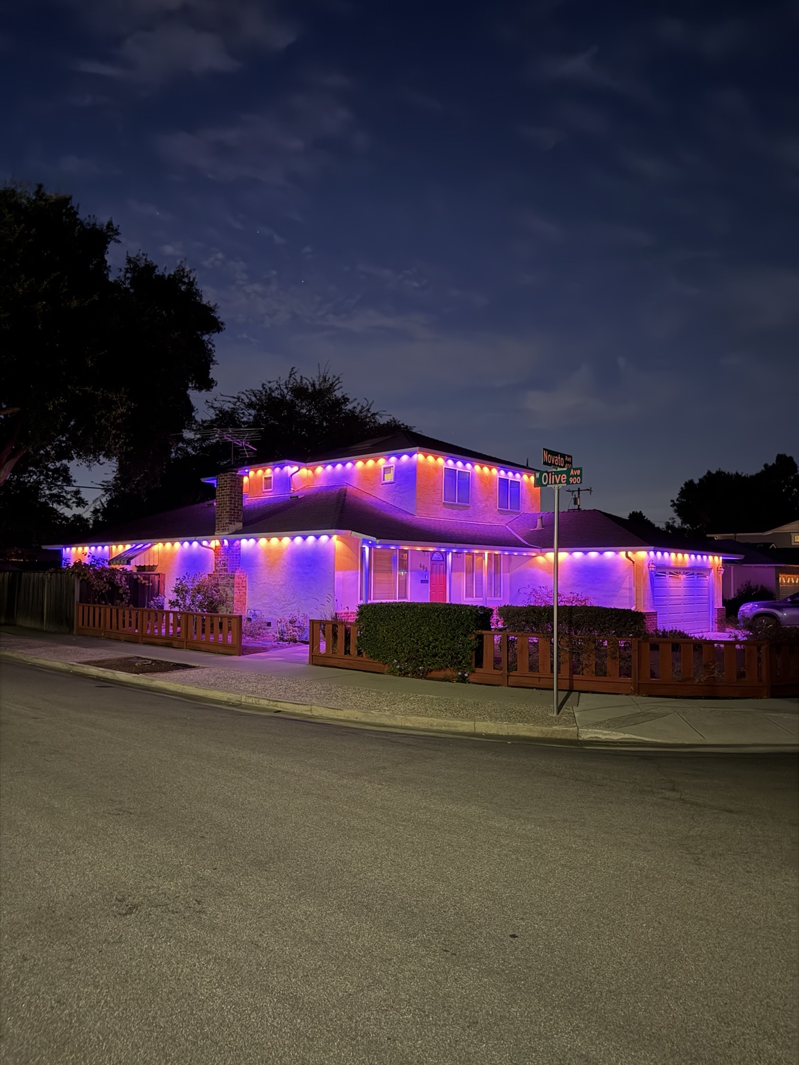 Corner-lot Bay Area home lit in purple and orange permanent RGB lighting for a party at night