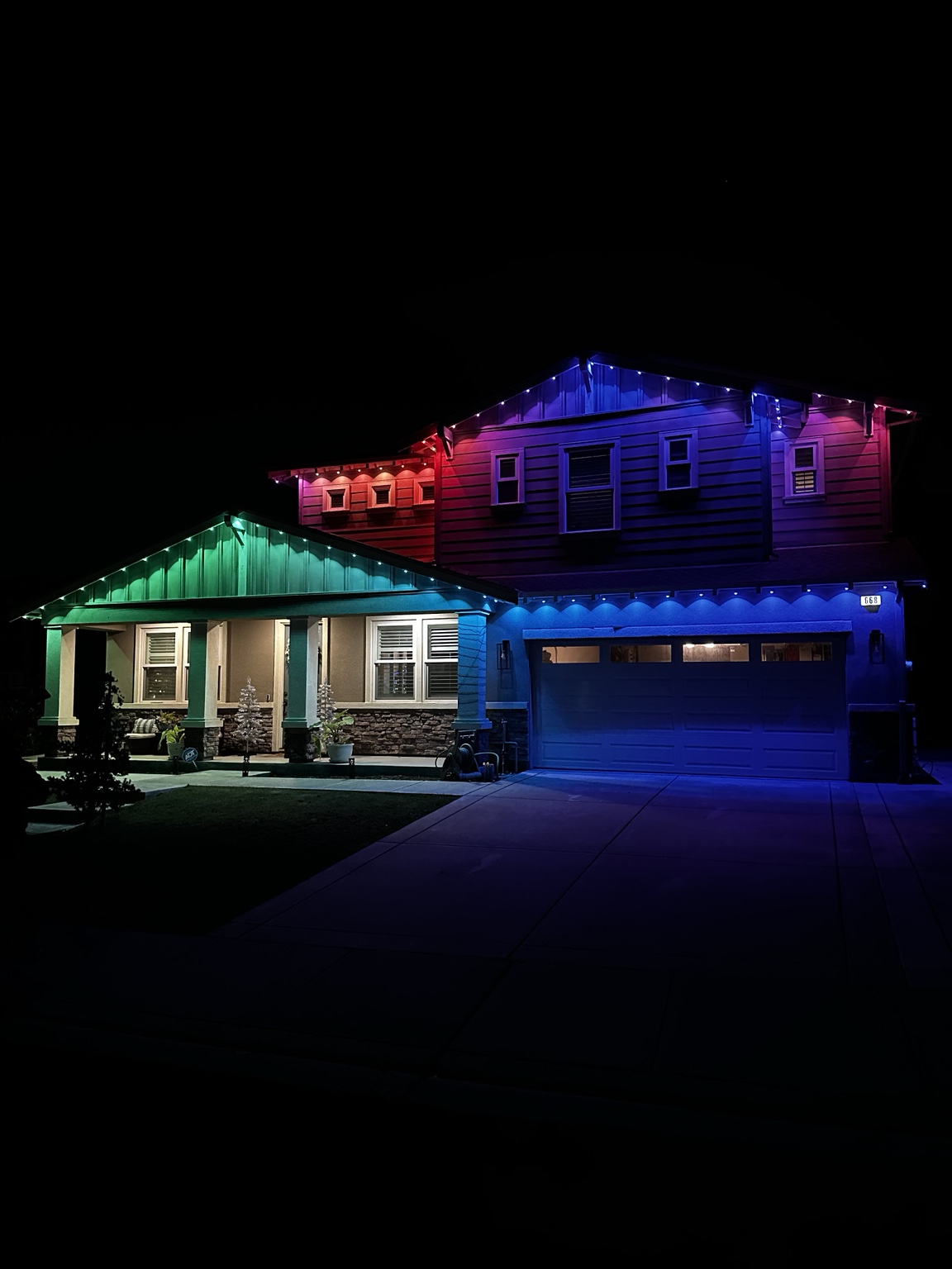 Two-story home lit in red, blue and purple permanent lighting for the Fourth of July