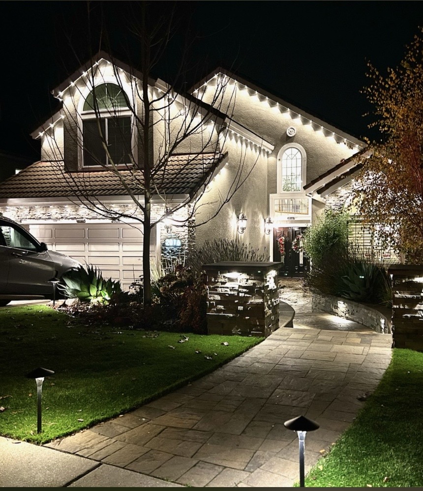 Two-story Bay Area home at night with warm white permanent Govee roofline lighting outlining every gable and landscape path lighting